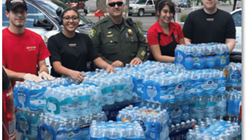 Group of people with tons of cases of bottled water