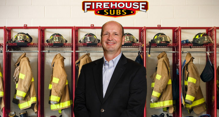 Chris Holmes, in front of locker with firefighter gear