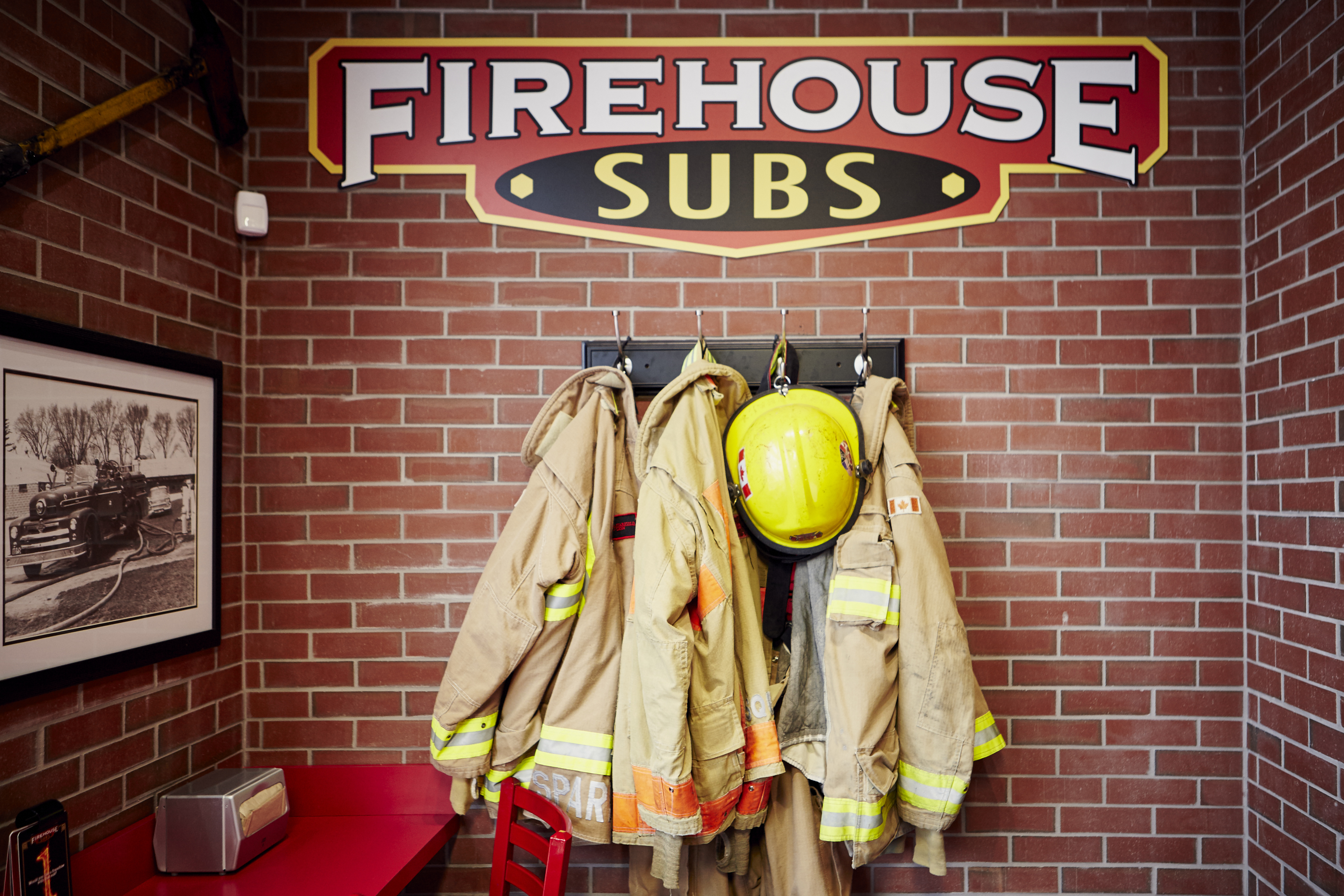 Firefighter gear hanging off of a brick wall
