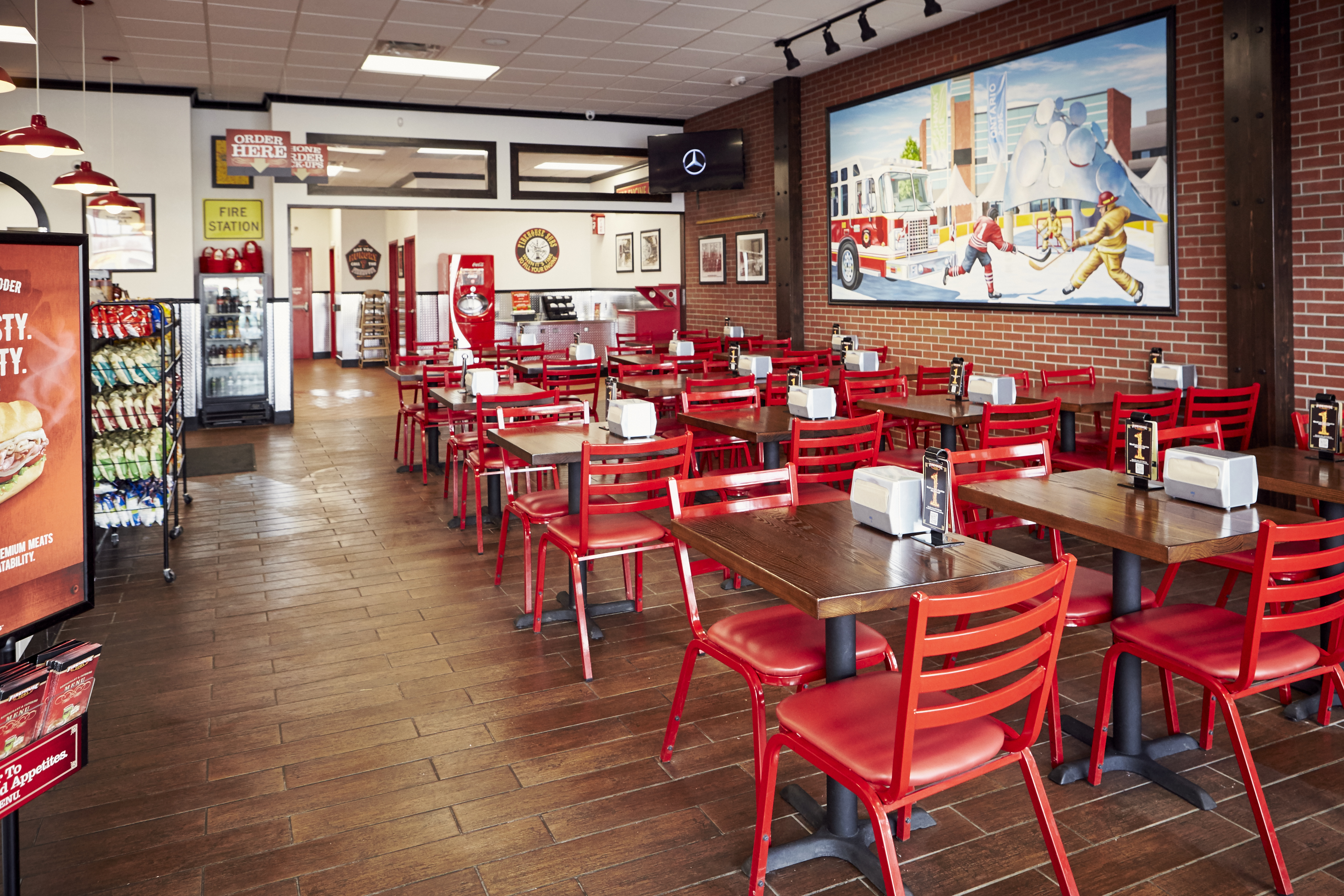 Interior photo of a restaurant's wood tables and red chairs Interior photo of a restaurant's wood tables and red chairs
