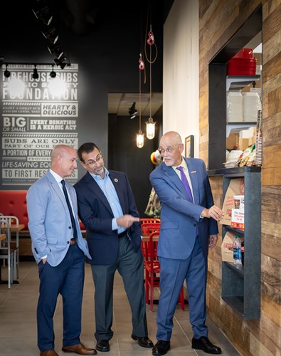 Three men wearing business attire in a Firehouse location